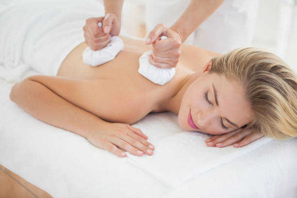 istock Beautiful blonde enjoying a herbal compress massage 844309164