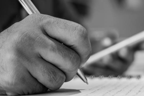 istock Close up of a man hand writing on his notebook while holding a mobile smart phone 844314990