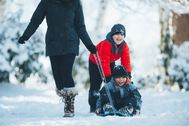 istock Mom and sons playing in snow 844319746