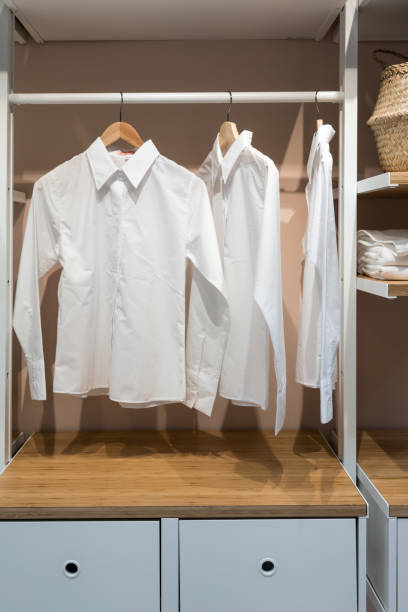 istock White basic shirts hanging in walk in closet with drawer for interior design. 844323232