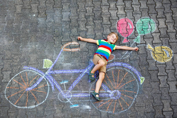 istock little kid boy having fun with bicycle chalks picture on ground 844323648