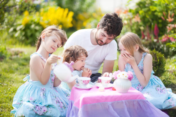 istock Having many children father paying tea party with daughters. 844327262