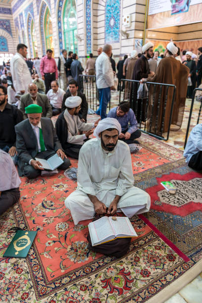 Qom- Iran Qom- Iran. -may 14,2013: Men in traditional costumes pray at the Fatima Masumeh shrine. The shrine of Fatema Masumeh is located in Qom which is considered by Shia Muslims to be the second most sacred city in Iran after Mashhad. Much of the shrine complex was first built by Shah Abbas I in the early 17th century. mullah photos stock pictures, royalty-free photos & images