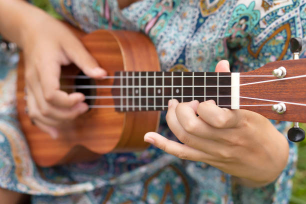 ukulel を演奏若い女性のクローズ アップ写真。 - ukelele ストックフォトと画像