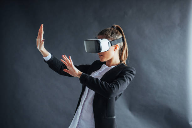 istock Happy woman on background in the studio gets the experience of using VR-glasses virtual reality headset 844346686