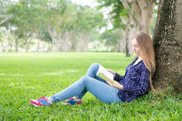 istock Calm young student reading book in tranquil park 844347018