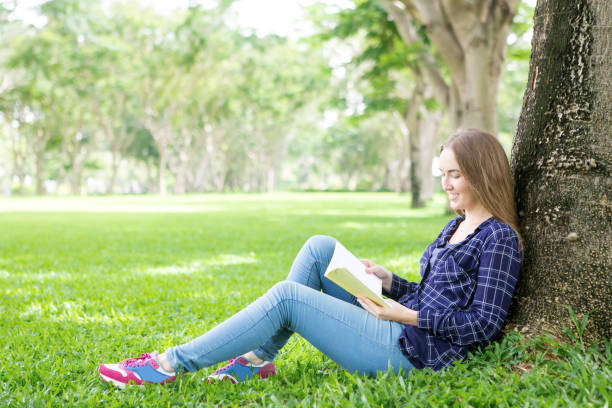 istock Positive student girl adoring reading book 844347102