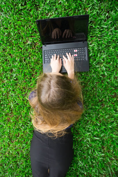 istock Girl Working on Laptop Computer on Grass 844347394
