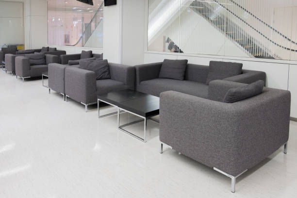 istock Dark grey fabric sofa in waiting room or contemporary office interior with lounge area, workplaces. empty room. 844350082