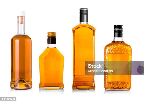 Set Of Beautiful Whisky Bottles Against Well Lit Background Stock Photo - Download Image Now