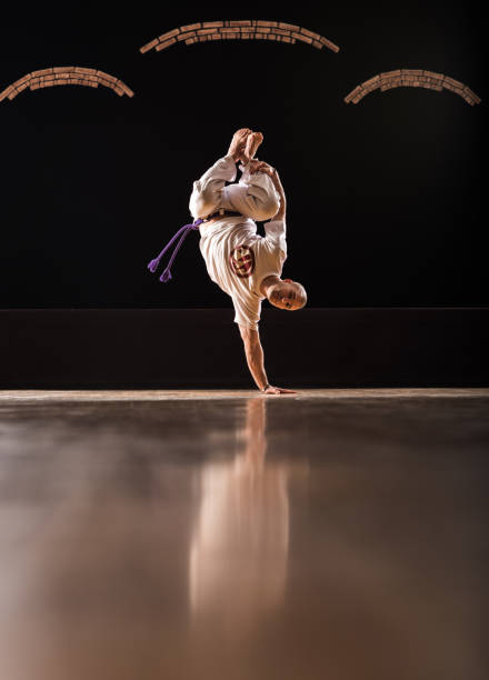 istock Capoeira athlete doing a handstand on a floor and looking at camera. 844350622