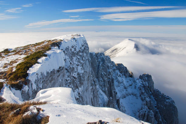 istock Mountain peak above the clouds. Sunny winter day on mountain above the clouds. 844350724