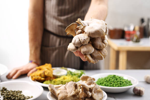 Chef holding oyster hats in hand.