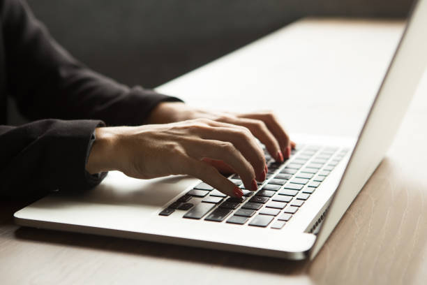 istock Close-up of female hands typing on laptop at table 844356558