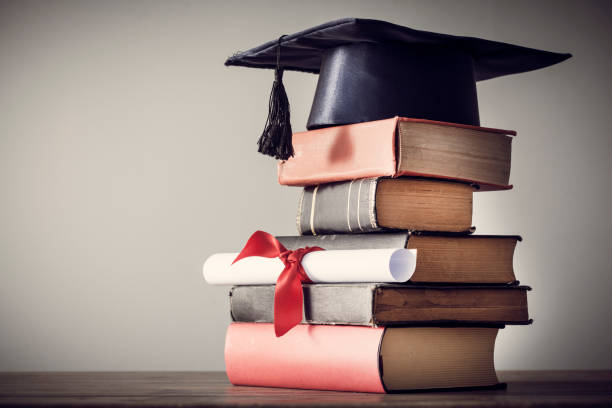 istock Graduation hat and diploma with book on table 844357130