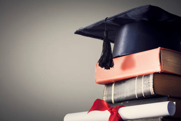 istock Graduation hat and diploma with book on table 844357264