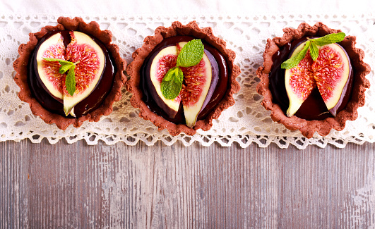 Chocolate mini tarts with chocolate ganache filling and fig on top. Overhead shot with copyspace