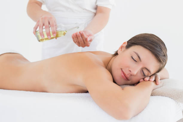istock Attractive woman getting massage oil on her back 844364682