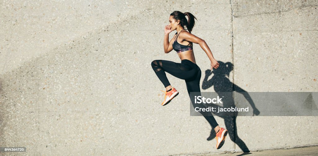 Woman doing fitness exercise outdoors Fit woman exercising outdoors. Healthy young female athlete doing fitness workout. Health Club Stock Photo