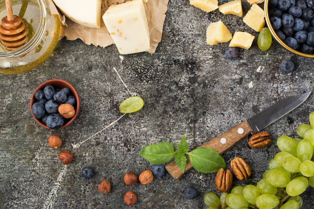 istock Cheese board for snacks, tricks, meetings with friends, on a gray stone background: assorted cheeses, young cheese, parmesan, cheese with fenugreek, figs, nuts, honey, grapes. Top View. 844364946