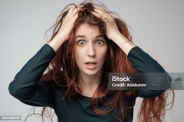 Pretty Caucasian Woman Trying To Comb Hair Shocked Emotion On Face Stock Photo - Download Image Now