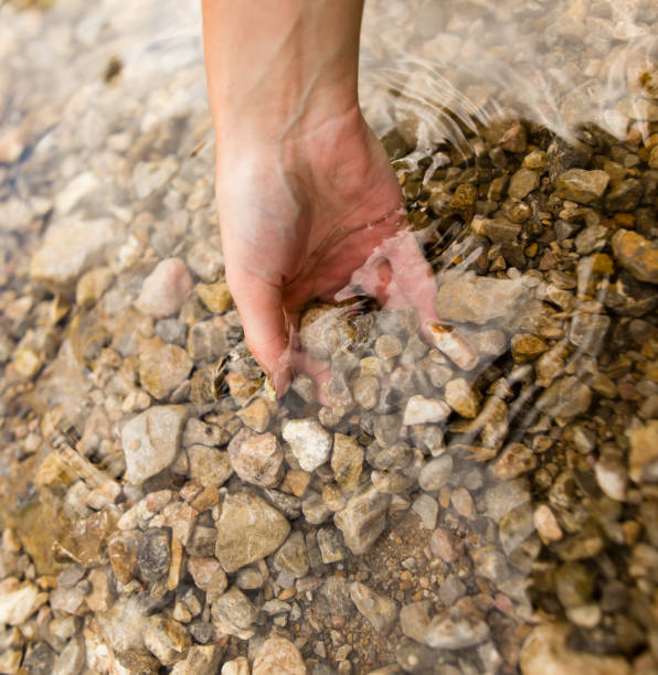 istock Small stones in the hand on the pond 844368060
