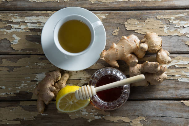istock Overhead view of fresh honey and lemon with ginger tea on weathered table 844378984