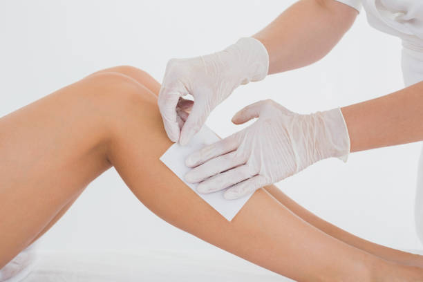 istock Therapist waxing womans leg at spa center 844379284