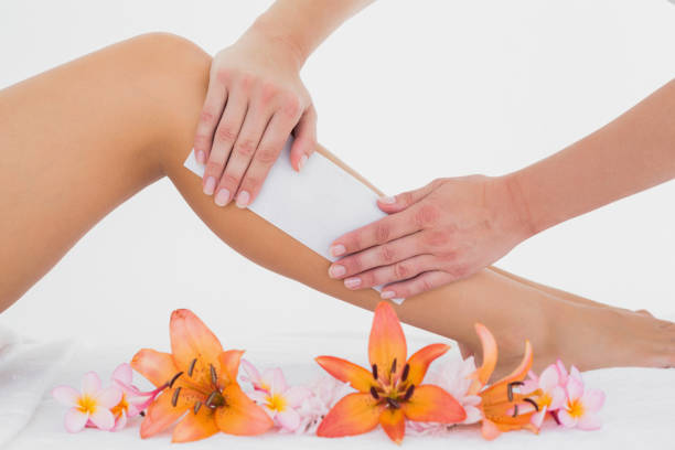 istock Therapist waxing womans leg at spa center 844379368