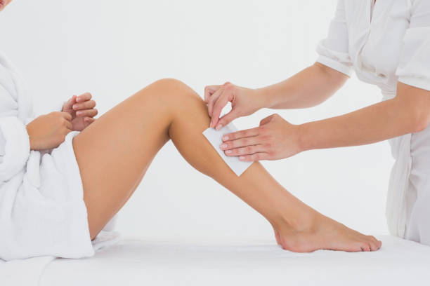 istock Therapist waxing womans leg at spa center 844379424