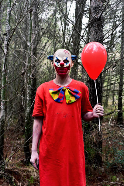 istock scary evil clown with a red balloon in the woods 844383224