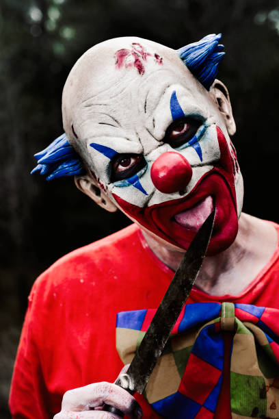 istock scary evil clown with a knife in the woods 844383318