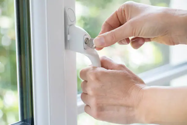 Photo of Close Up Of Woman Turning Key In Window Lock