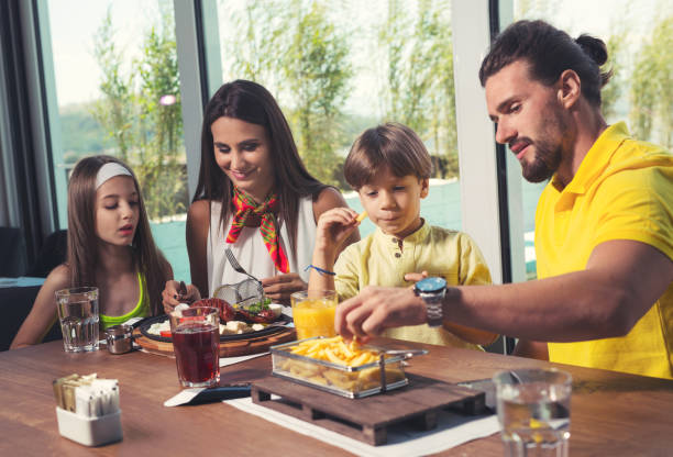 istock Family having enjoyable lunch at a restaurant. 844389164