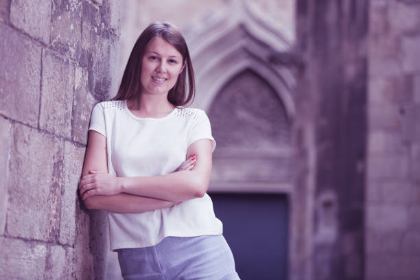 istock Young woman standing near old stone wall 844389238