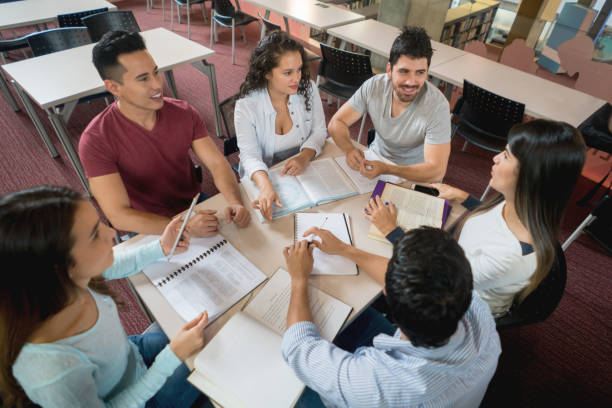 istock Group of university students studying together at the library 844393036