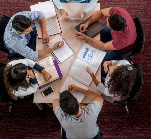 istock Group of university students studying at the library 844393172