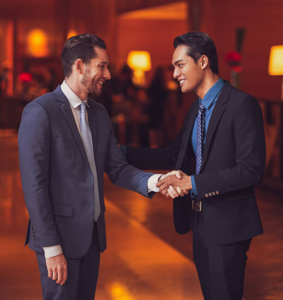 istock Two Smiling Partners Shaking Hands in Lobby 844393660