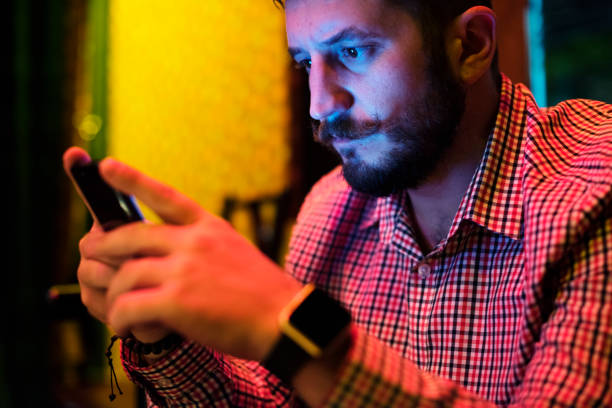 istock Closeup of a man using mobile phone in the dark with long exposure light 844394118