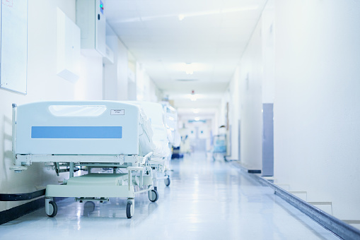 Shot of a hospital bed in an empty corridor of a modern hospital