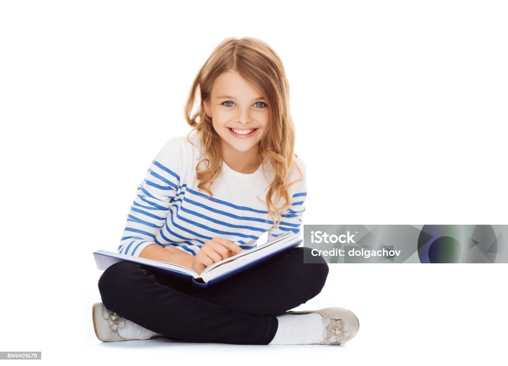 girl reading book education and school concept - little student girl sitting on floor and reading book Child Stock Photo