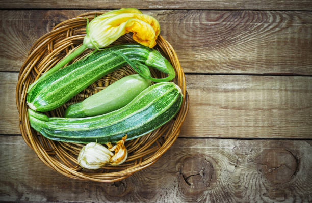 istock Fresh zucchini on wicker mat on dark wooden background 844409444