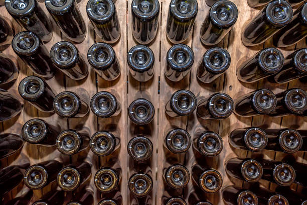 Close up wine bottles aging in wooden stand