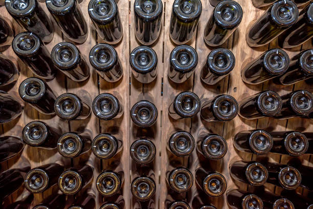 Bottoms of wine bottles stacked in cellar stock photo