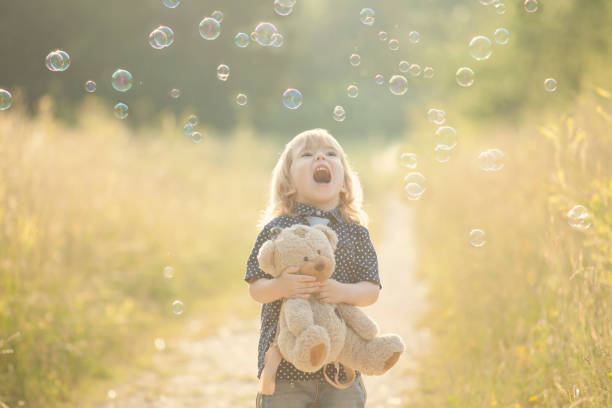 istock Little boy playing with soap bubbles and bear toy 844417924