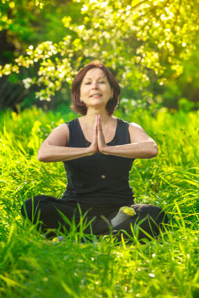 istock beautiful woman doing yoga outdoors On green grass 844421052