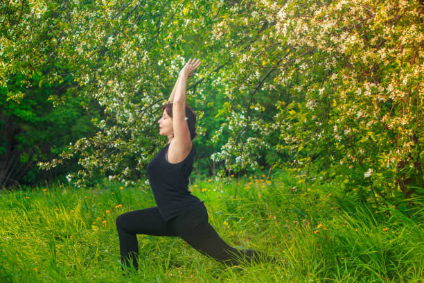 istock beautiful woman doing yoga outdoors On green grass 844423516