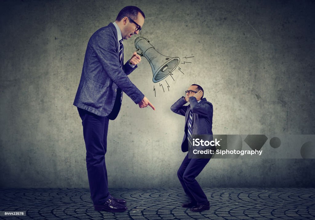 Angry business man boss screaming at himself small in megaphone Scolding Stock Photo