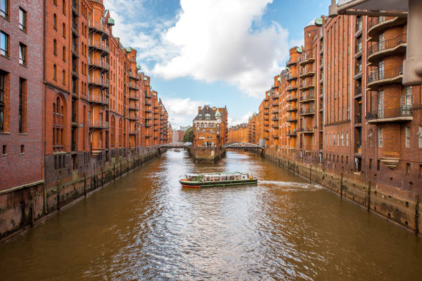 A gray-scale shot of boats in the river with building on the side in Hamburg, Germany