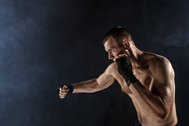 istock The young man kickboxing on black 844444352